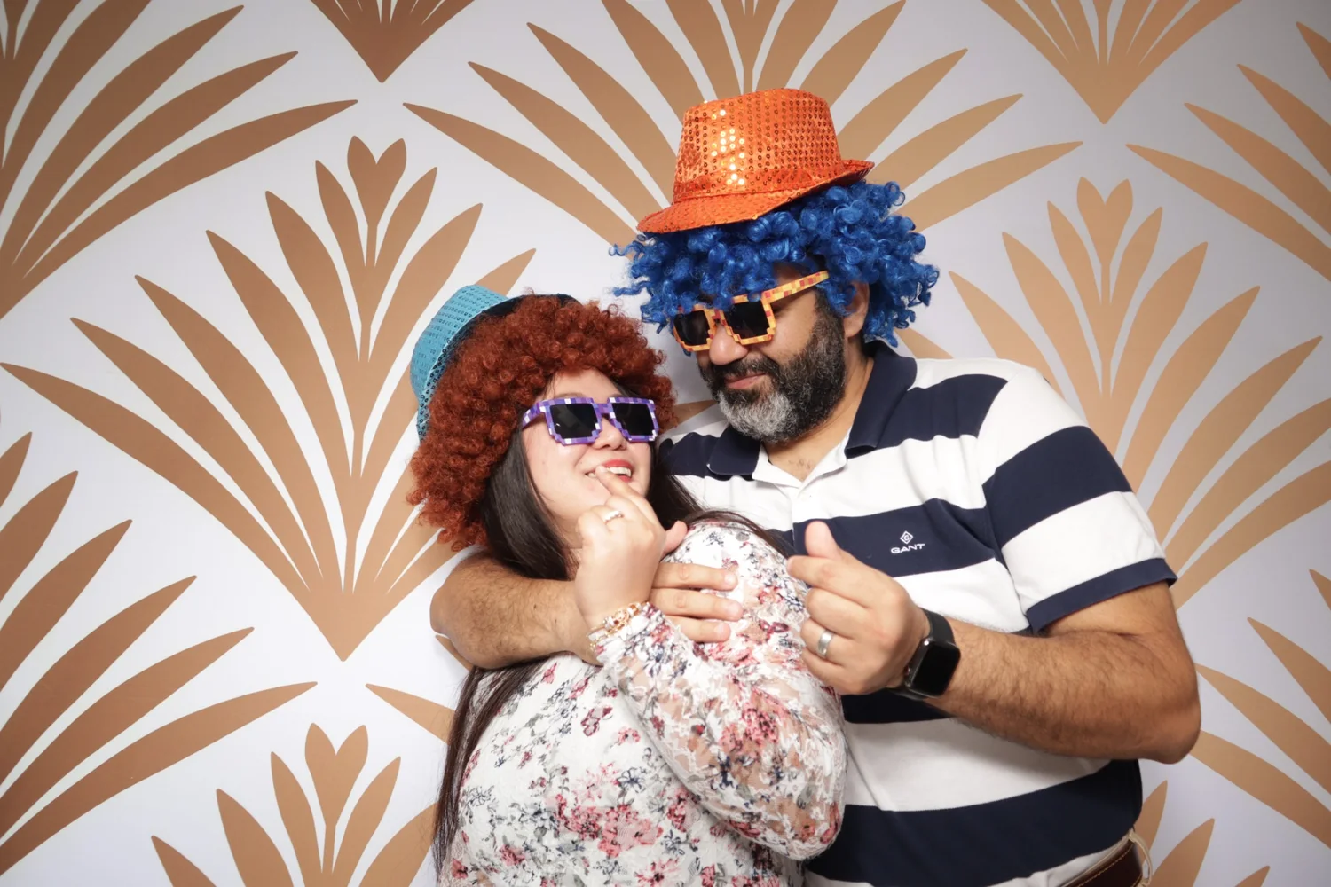 Guests wearing colorful wigs and novelty glasses in a photo booth