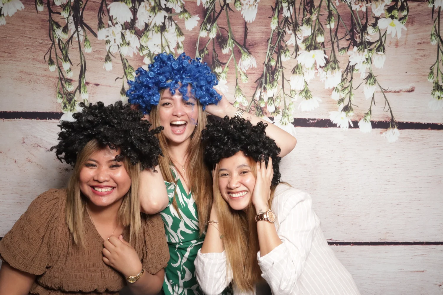 Three guests enjoying a colorful photo booth session